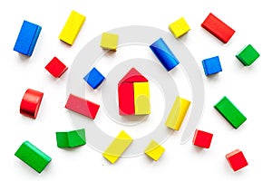 Construction game for kids. Wooden building blocks, toy bricks on white background top view