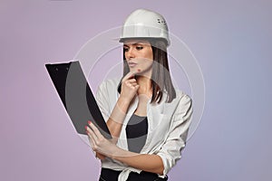 Construction girl in a white helmet, holding a folder. the concept of a business woman who understands construction, repair and
