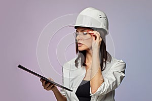 Construction girl in a white helmet, holding a folder. the concept of a business woman who understands construction, repair and