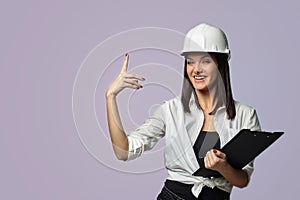 Construction girl in a white helmet, holding a folder. the concept of a business woman who understands construction, repair and