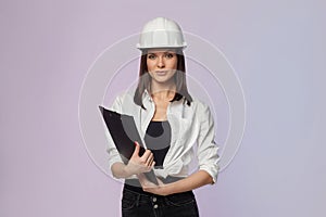 Construction girl in a white helmet, holding a folder. the concept of a business woman who understands construction, repair and