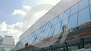 Construction of a glass facade of an office building. Master builders carry out repair work on the facade of the house