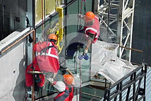 Construction of a glass wall, crane and industrial climbers. photo
