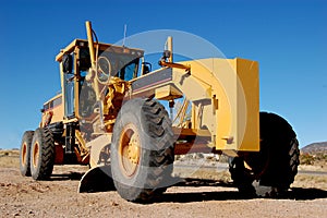 Construction grader on dirt road
