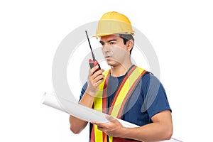 Construction handsome man worker in yellow helmet and reflective vest and using walkie talkie for talking with team staff isolated