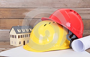 Construction hard hat and drawings and a small house model