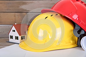 Construction hard hat and drawings and a small house model