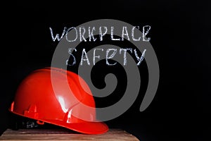 Construction helmet on a black background with the inscription workplace safety . Safety concept