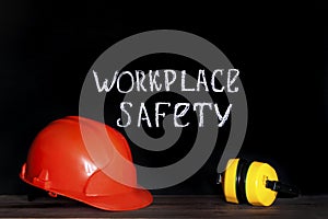 Construction helmet on a black background with the inscription workplace safety . Safety concept