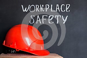 Construction helmet on a black background with the inscription workplace safety . Safety concept