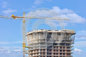 Construction with the help of a tower crane of the top of a multi-storey residential building using a monolithic-frame method