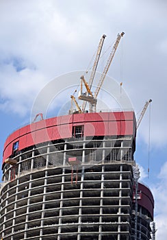 Construction of high-rise building with  Tower  cranes on clear sunny day