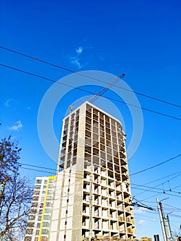 Construction of high-rise buildings in Ivano-Frankivsk. Construction crane. Building against the blue sky