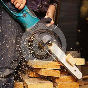 Construction of a house, a man works with a circular electric saw and an electric jigsaw