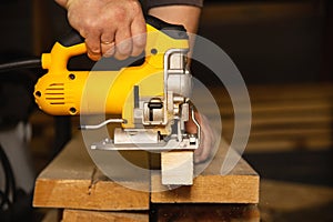 Construction of a house, a man works with a circular electric saw and an electric jigsaw