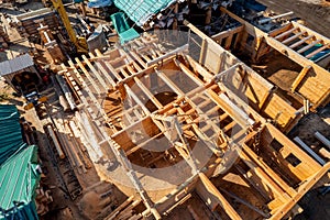 Construction industry concept. Timber wooden frame of house from bar, foundations of villas. Aerial top view