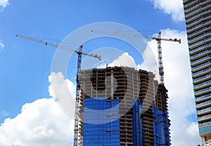 Construction industry image of tall cranes and building exterior