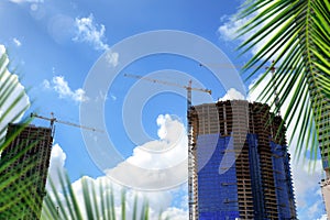 Construction industry image of tall cranes and building exterior