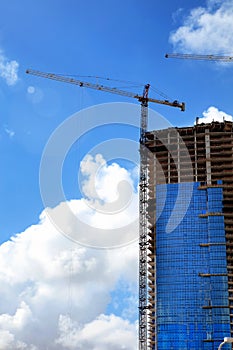 Construction industry image of tall cranes and building exterior