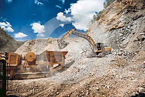 Mining and construction industry - industrial excavator loading rocks and gravel into machinery
