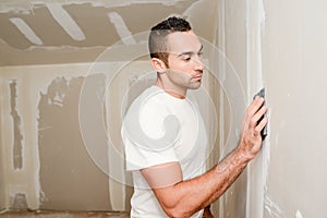 Construction industry worker with tools plastering walls and renovating house in construction site