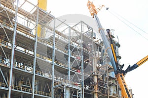 Construction and installation work with a powerful construction crane of a large new industrial oil refining petrochemical