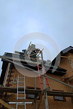 Construction and insulation of a new house with facade bricks, construction work and wooden scaffolding