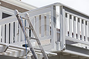 Construction Ladder and Painting Hose Leaning on House Deck