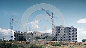 Construction location with silhouette of jib crane in with stormy clouds floating in wind. Time lapse construction building