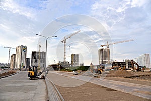 Construction machinery and Equipment on road work. Excavator on earthmoving at construction site. Tower cranes in action on blue