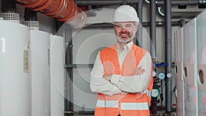 Construction male worker with grey hair smiling standing in boiler room