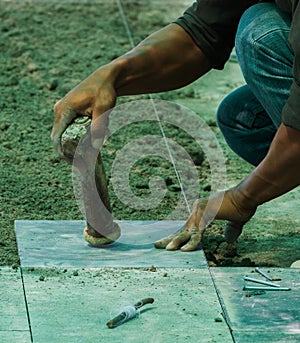 Construction man worker floor tile installation.