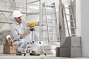 Construction man worker measure with level laser wear hard hat and protective glasses  at interior building site