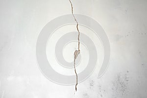 Construction man worker repairing a crack wall of a home, plastering cement on wall. Builder applying white cement to a