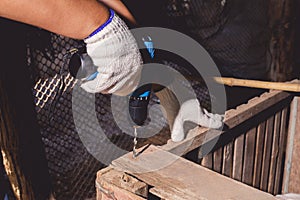 Construction man workers in blue shirt with Protective gloves and working with power drill