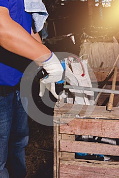 Construction man workers in blue shirt with Protective gloves and working with power drill