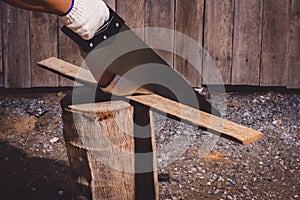 Construction man workers in blue shirt with Protective gloves working with saw