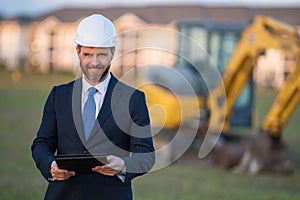 Construction manager in suit and helmet at a construction site. Construction manager worker or supervisor wearing