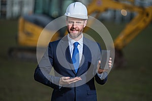 Construction manager in suit and helmet at a construction site. Construction manager worker or supervisor wearing