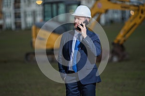 Construction manager in suit and helmet at a construction site. Construction manager worker or supervisor wearing