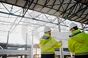 Construction managers reviewing blueprints or project plans.