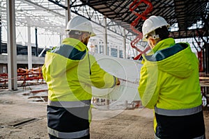 Construction managers reviewing blueprints or project plans.