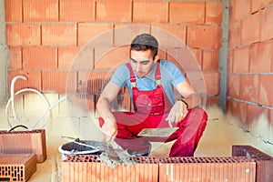 Construction mason, industrial worker with tools building walls