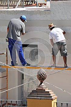 Construction mason renovating the facade of a house