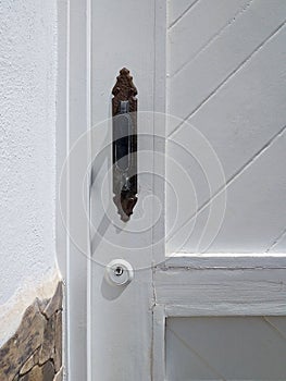 Black lock and handle detail on white painted wooden door. Old fashion retro and vintage style black color brass metal Door knob