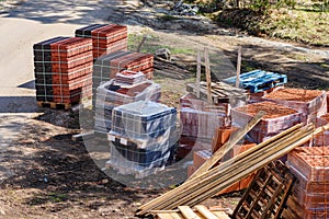 Construction material on building site - planks, blocks and roof tiles