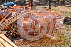 Construction material on building site - planks, blocks and roof tiles