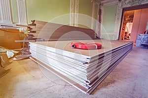 Construction materials and sheets of plasterboard or drywall are prepared for working process of installing plasterboar