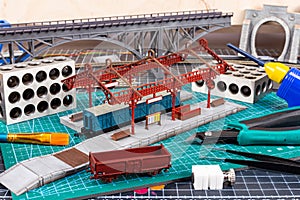 Construction of model railroad layout. workbench with model railway train station bridge tracks and landscape tools. hobby leisure