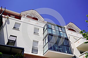 Construction of modern white building with balcony windows on blue sky background